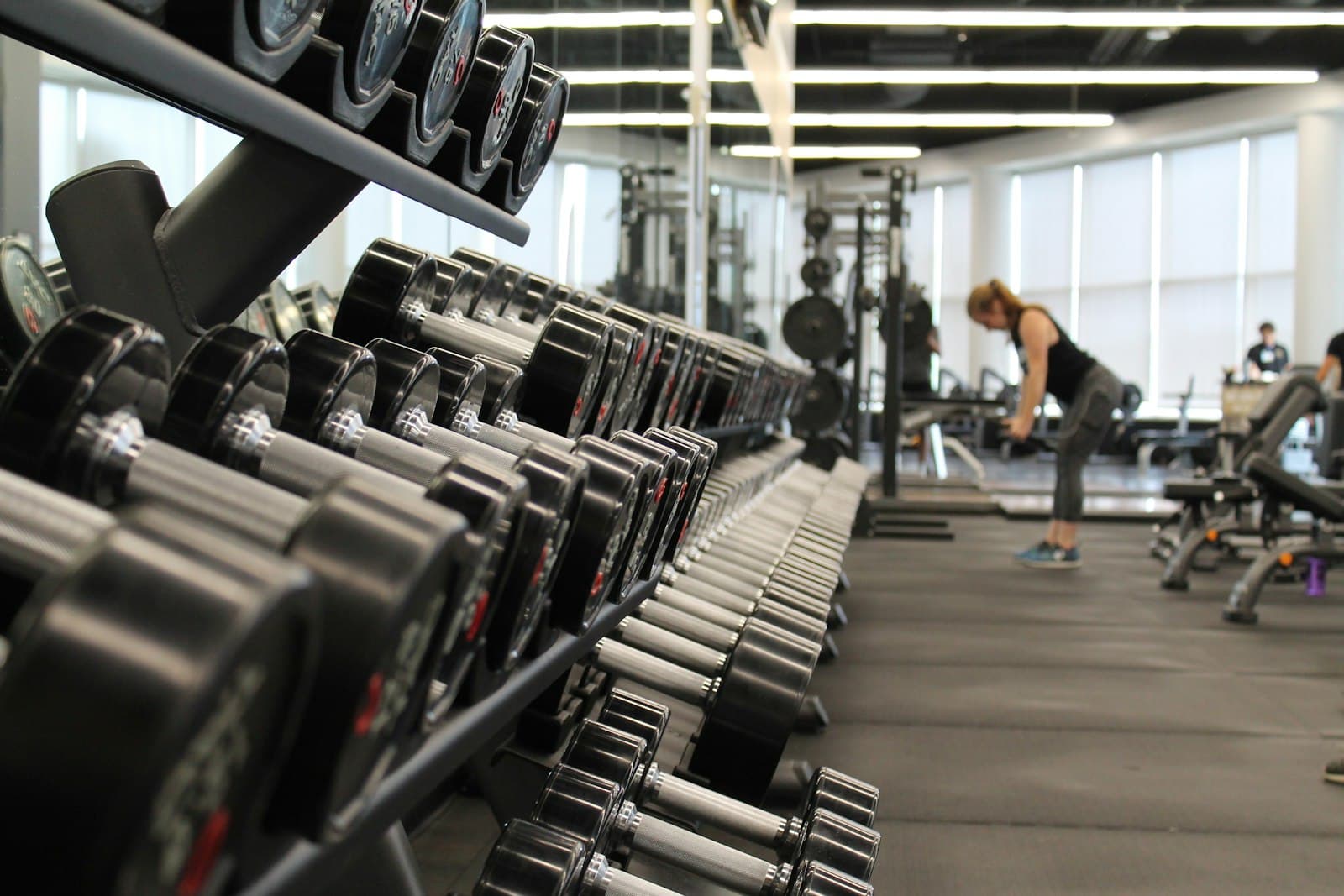 Dumbbell rack and a member training on the floor at KORE Sofia